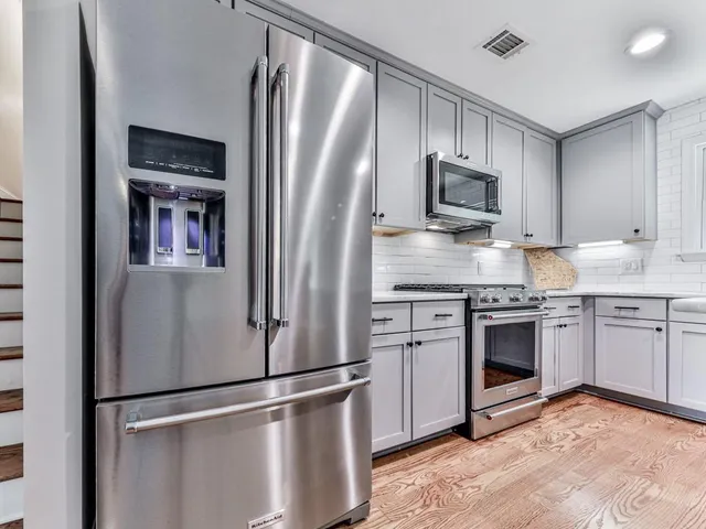 a kitchen with stainless steel appliances granite countertop a refrigerator stove a sink and dishwasher