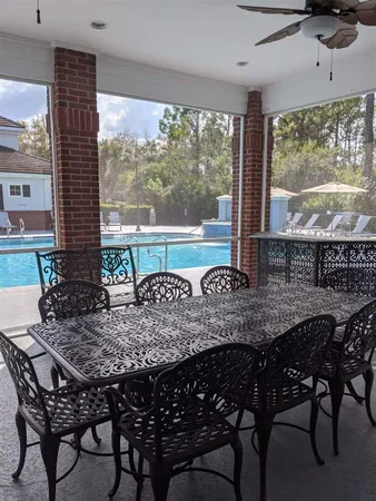 a view of a patio with couches table and chairs under an umbrella