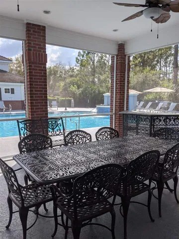 a view of a patio with couches table and chairs under an umbrella