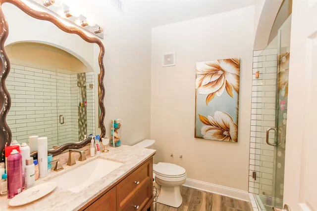a bathroom with a granite countertop toilet sink and mirror