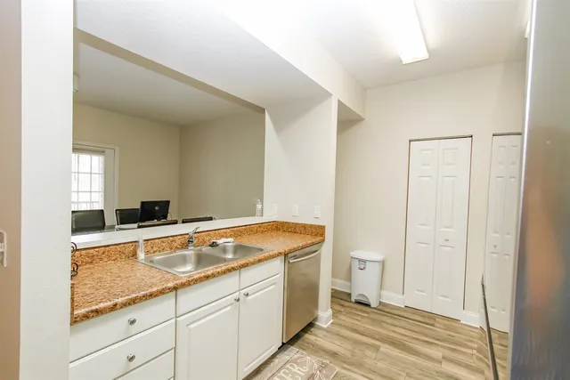 a spacious bathroom with a granite countertop sink and a mirror