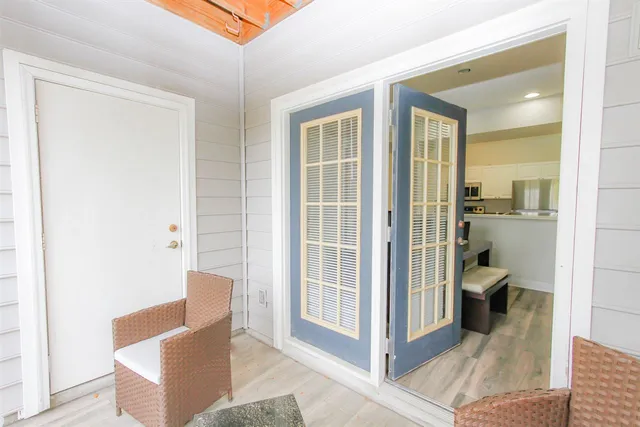 a view of a hallway with livingroom and furniture