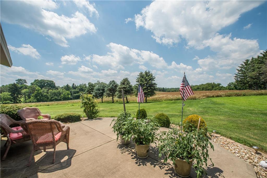 662 Bocktown Cork Road Clinton, PA 15026 - Photo 23 of 25 A patio is accessed from the sunroom and overlooks the rear acreage. The current owner allows a neighboring farmer to grow alfalfa on the back acres which is seen here bordering the mowed area.