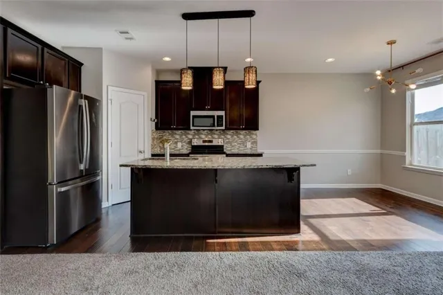 a kitchen with granite countertop a refrigerator and a sink