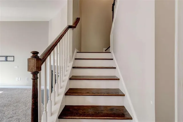a view of staircase with wooden floor and a rug