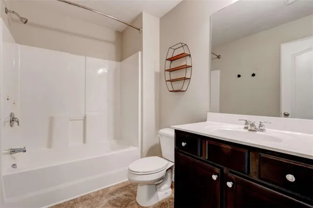 a bathroom with a sink toilet vanity and shower