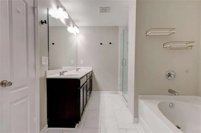 a bathroom with a tub sink vanity and a mirror