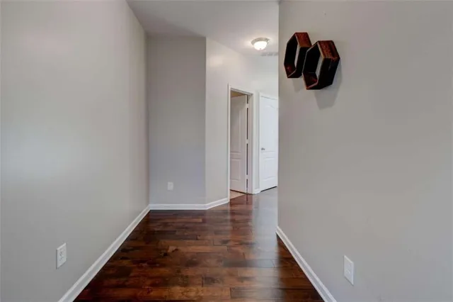 a view of a hallway with wooden floor and a bathroom