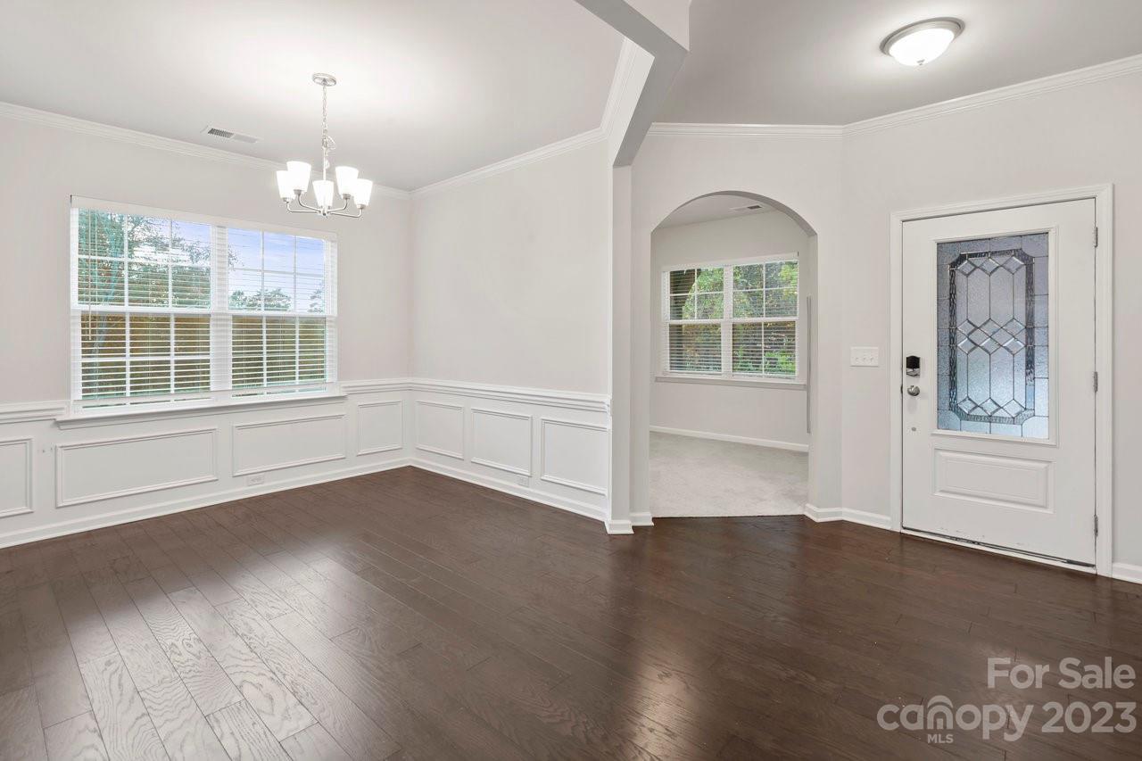 18209 Kalabash Road Charlotte, NC 28278 - Photo 14 of 48 an empty room with wooden floor chandelier and windows