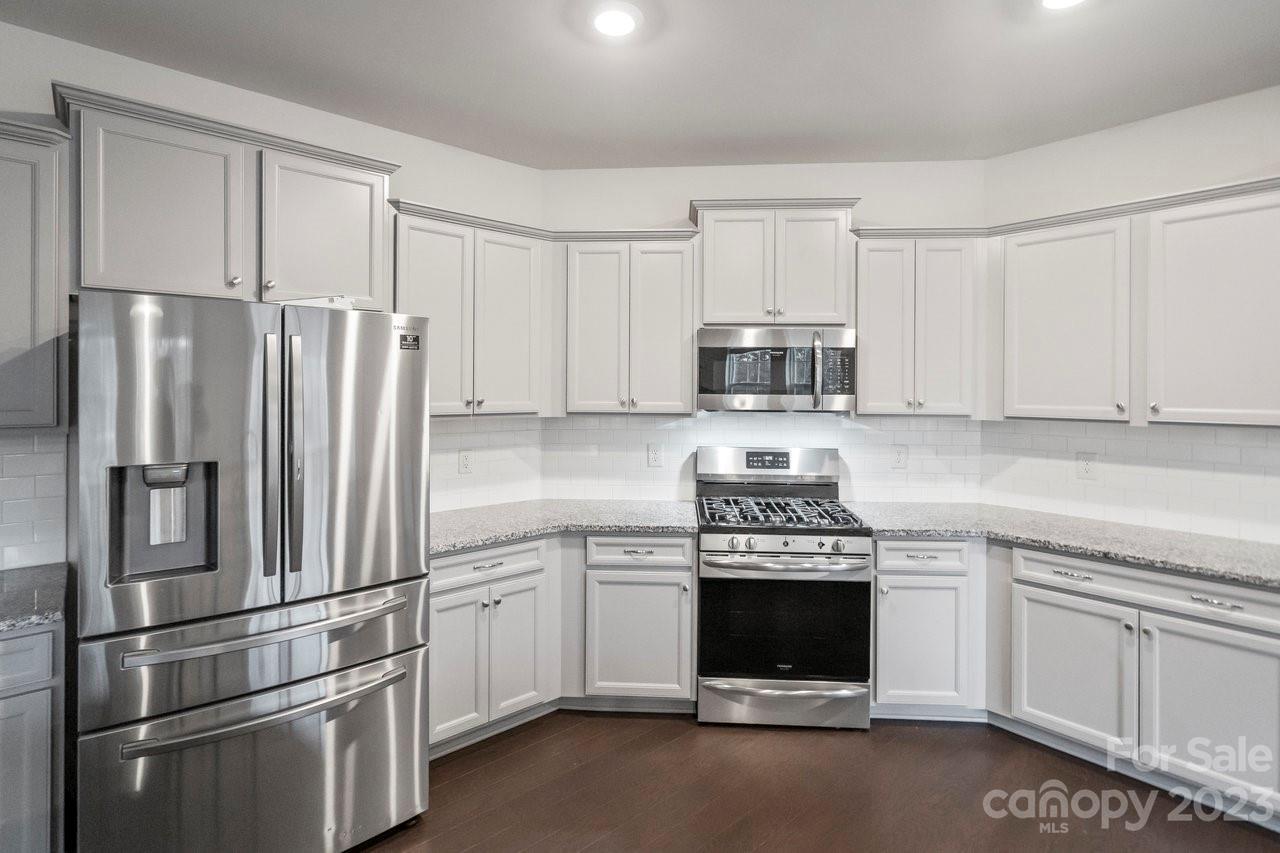 18209 Kalabash Road Charlotte, NC 28278 - Photo 8 of 48 a kitchen with a refrigerator stove and white cabinets