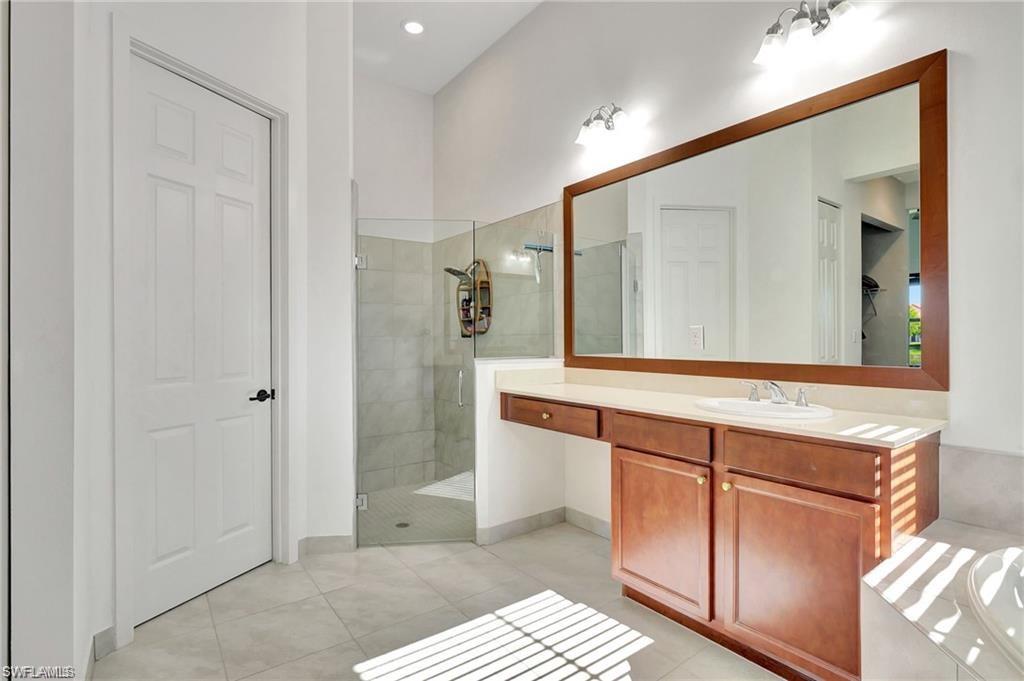 5123 Genoa Street Ave Maria, FL 34142 - Photo 16 of 34 a bathroom with a sink a mirror and a shower