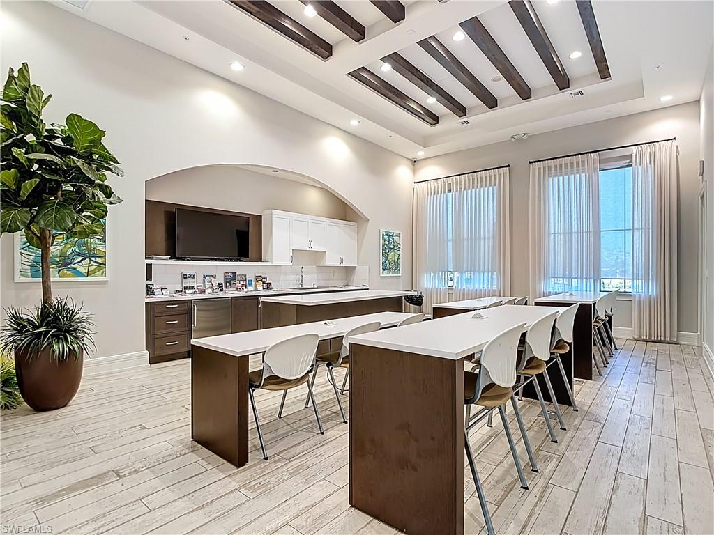 5123 Genoa Street Ave Maria, FL 34142 - Photo 24 of 34 a open kitchen with stainless steel appliances kitchen island granite countertop a sink dishwasher and white cabinets with wooden floor