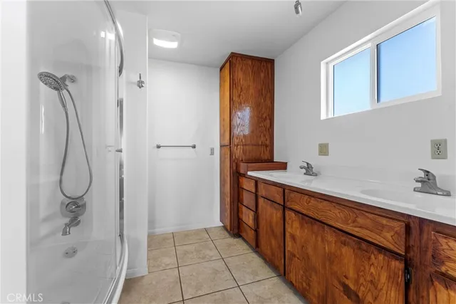 a spacious bathroom with a shower sink and mirror