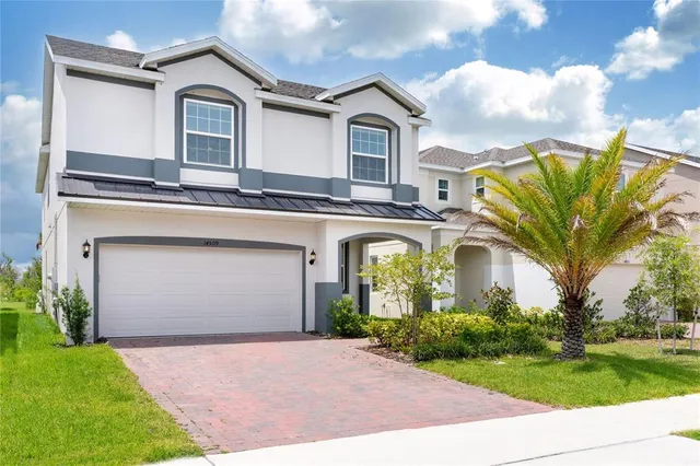 a front view of a house with a garden and trees