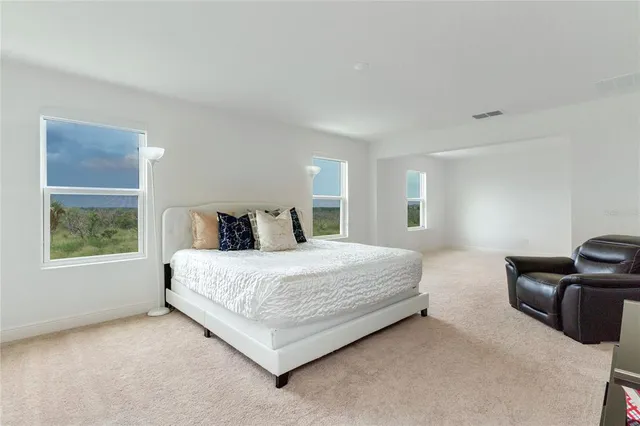 a spacious bedroom with a bed and window