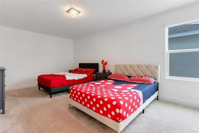 a bedroom with two beds and potted plant