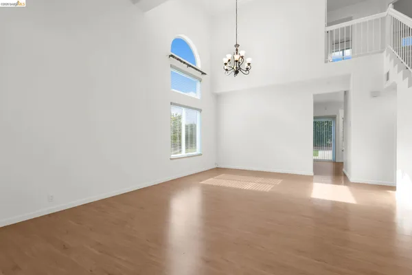 an empty room with windows and ceiling fan