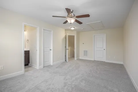 an empty room with closet and a ceiling fan