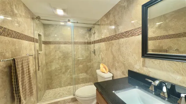 a bathroom with a sink a toilet and shower