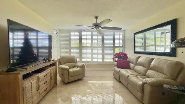a living room with furniture flat screen tv and a large window
