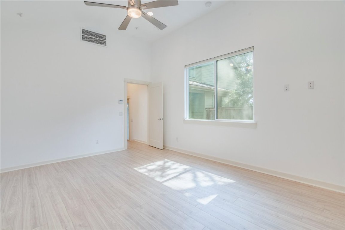 4006 Valley View Road, Unit B Austin, TX 78704 - Photo 8 of 32 an empty room with wooden floor fan and windows