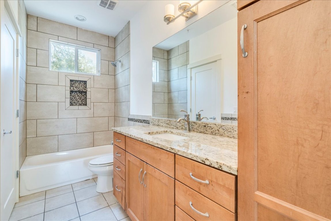 4006 Valley View Road, Unit B Austin, TX 78704 - Photo 18 of 32 a bathroom with a granite countertop sink a toilet and shower