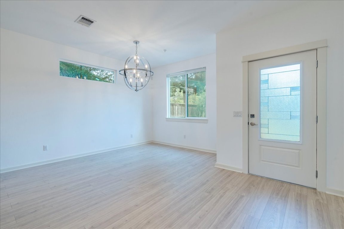 4006 Valley View Road, Unit B Austin, TX 78704 - Photo 4 of 32 an empty room with wooden floor chandelier and windows