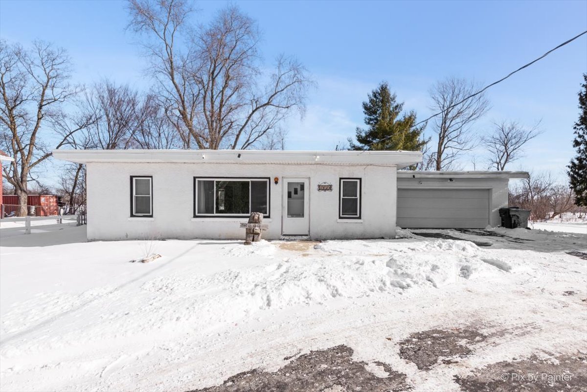 a front view of a house with a yard covered in snow