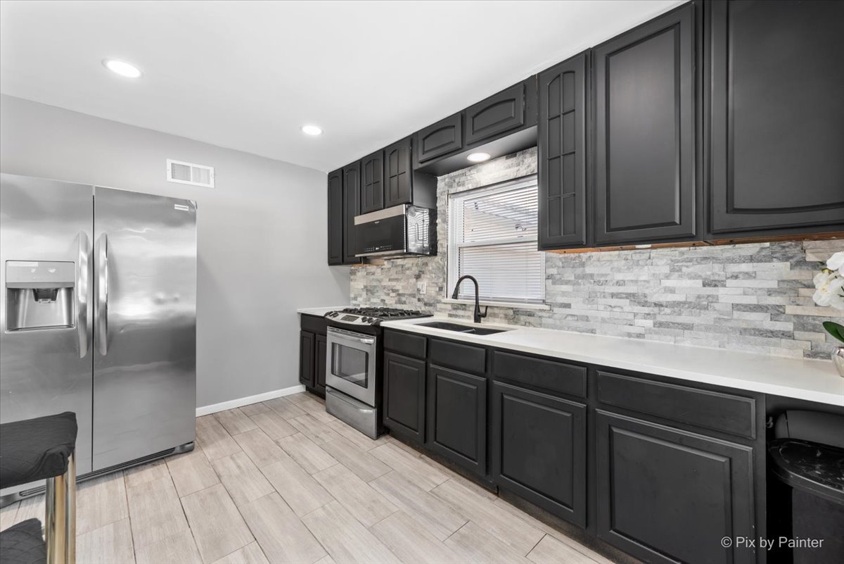 2629 North McAree Road Waukegan, IL 60087 - Photo 11 of 28 a kitchen with stainless steel appliances granite countertop a sink stove and refrigerator