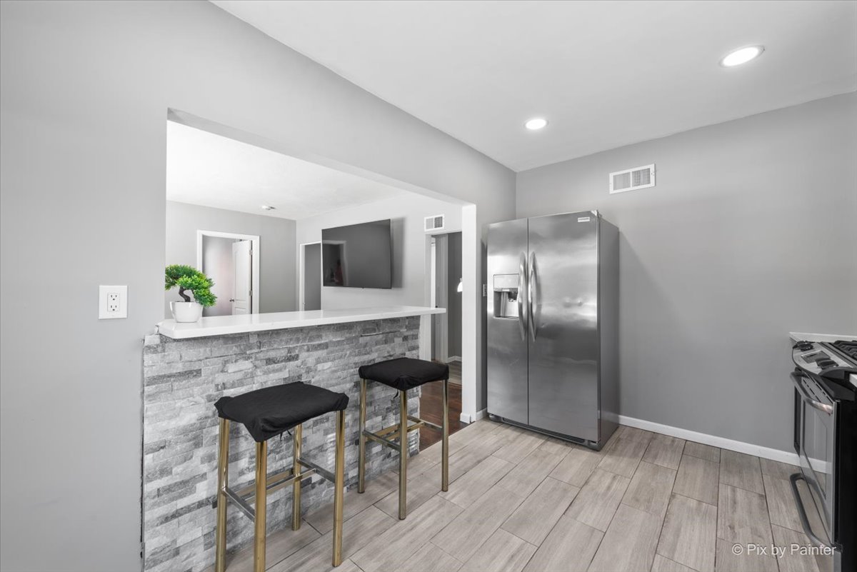 2629 North McAree Road Waukegan, IL 60087 - Photo 12 of 28 a view of kitchen island dining space wooden floor and dining room
