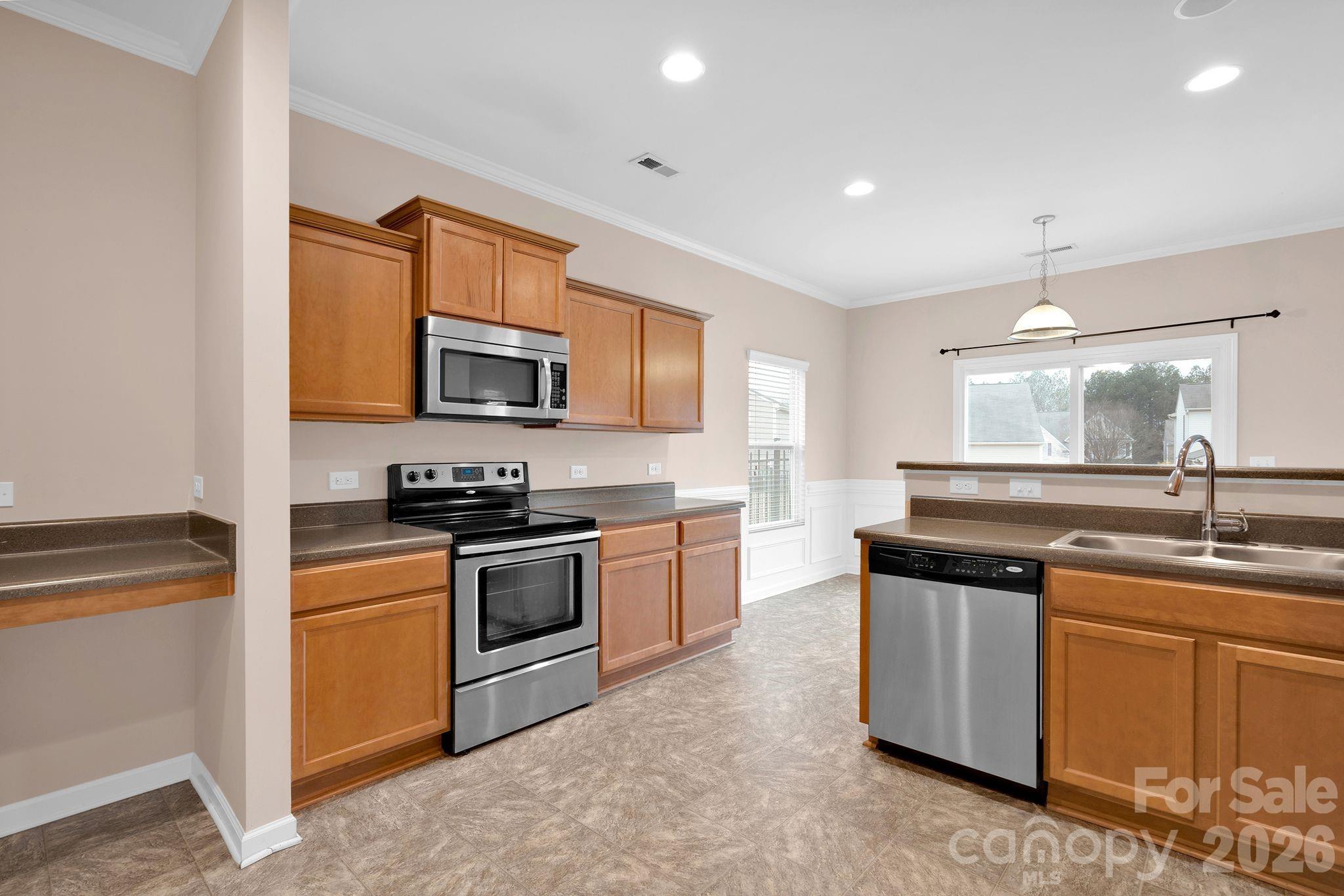 13718 Porter Creek Road Charlotte, NC 28262 - Photo 11 of 45 a kitchen with stainless steel appliances granite countertop a sink stove and microwave