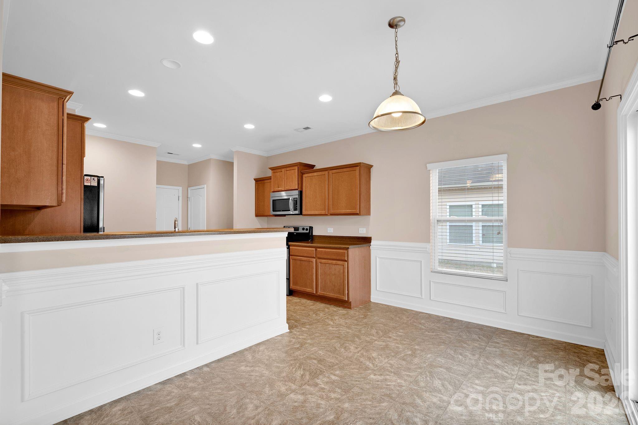 13718 Porter Creek Road Charlotte, NC 28262 - Photo 13 of 45 a large kitchen with granite countertop a stove a sink and a refrigerator