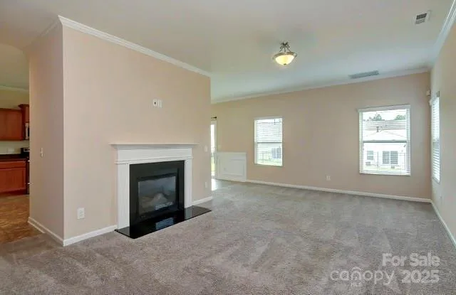an empty room with windows and fireplace