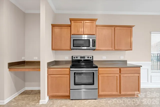 a kitchen with granite countertop a stove top oven microwave and cabinets