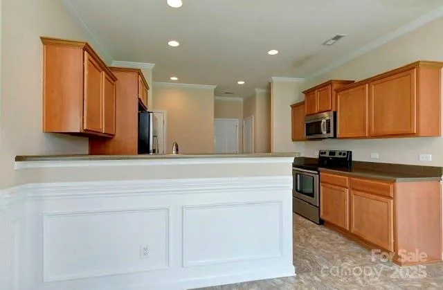 a kitchen with stainless steel appliances granite countertop a sink and a stove top oven with wooden floor