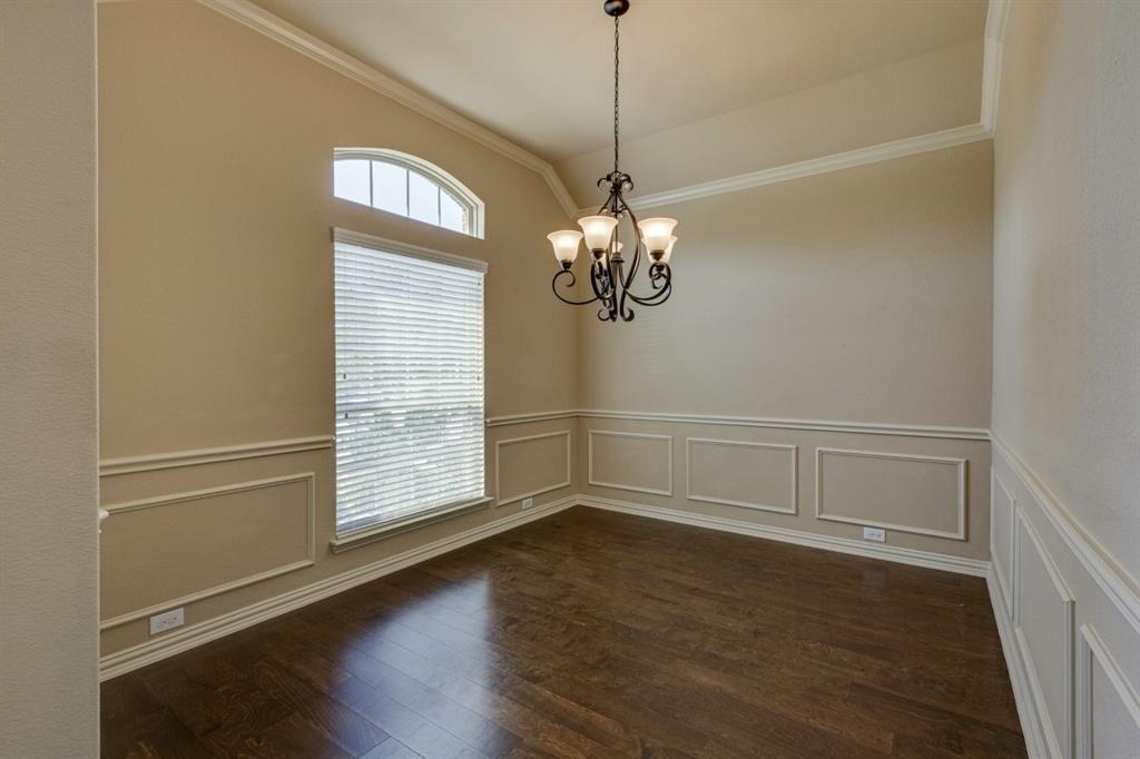 1522 Blue Jay Road Garland, TX 75043 - Photo 6 of 32 Room featuring rich wood-finish flooring, wainscoting and crown molding details, a decorative chandelier, and a large window with an arched transom