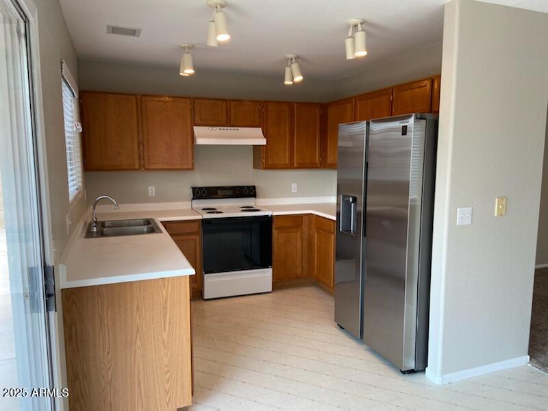 3233 West Abraham Lane Phoenix, AZ 85027 - Photo 4 of 13 a kitchen with stainless steel appliances a refrigerator sink and stove