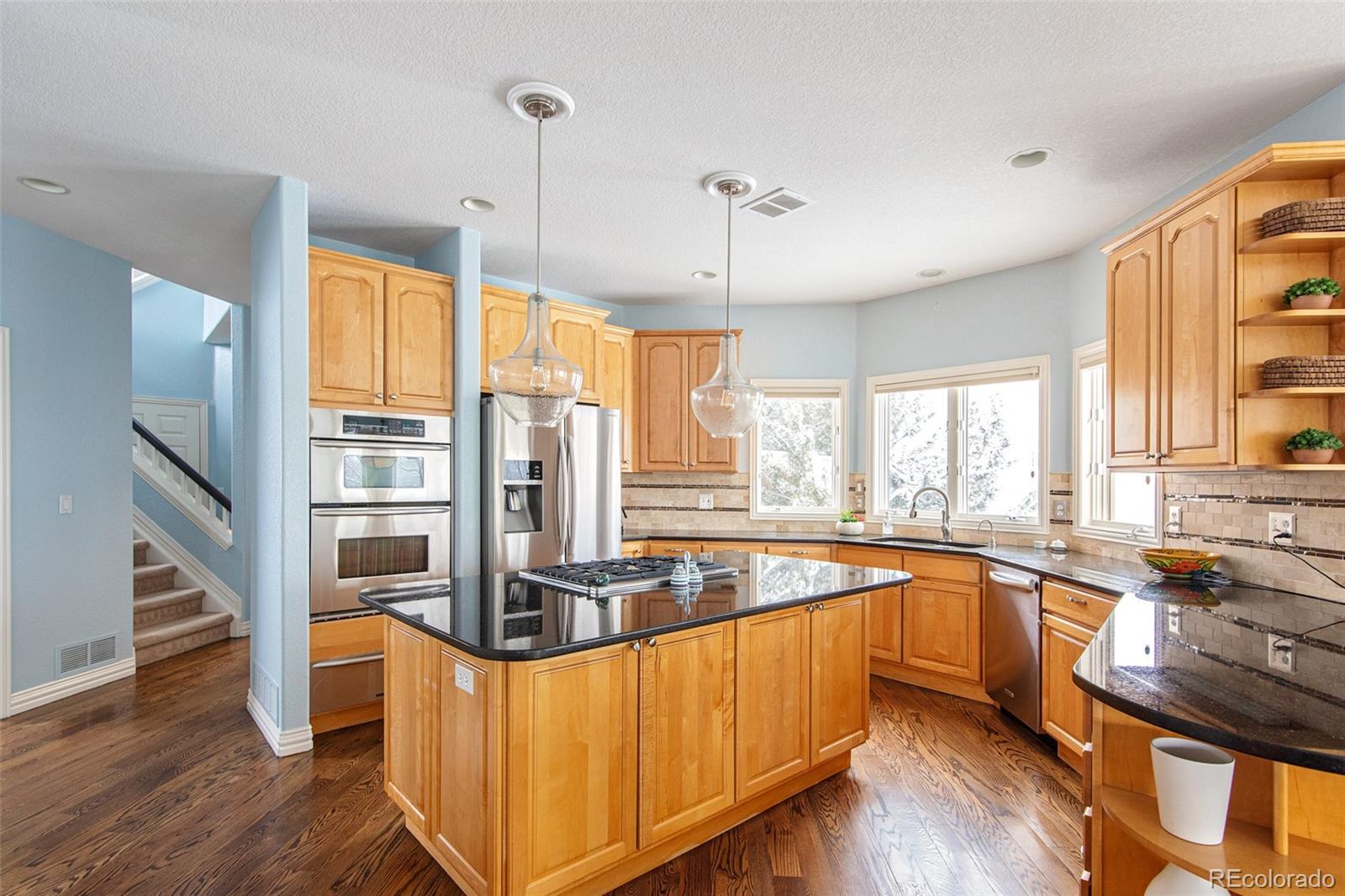 535 Sawtooth Point Lafayette, CO 80026 - Photo 7 of 40 a kitchen with stainless steel appliances granite countertop a stove and a wooden floors