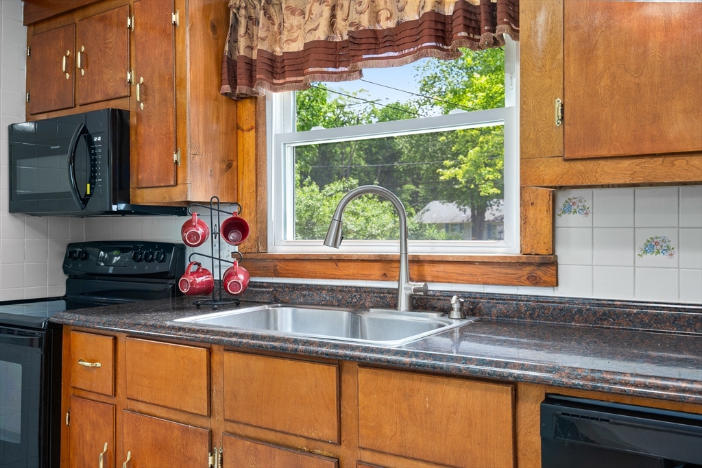 957 Ryan Road Northampton, MA 01062 - Photo 21 of 42 a kitchen with stainless steel appliances wooden cabinets a sink and a large window