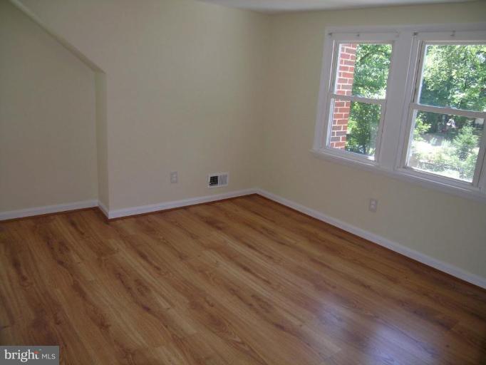 731 Overbrook Road Baltimore, MD 21212 - Photo 12 of 20 an empty room with wooden floor and windows