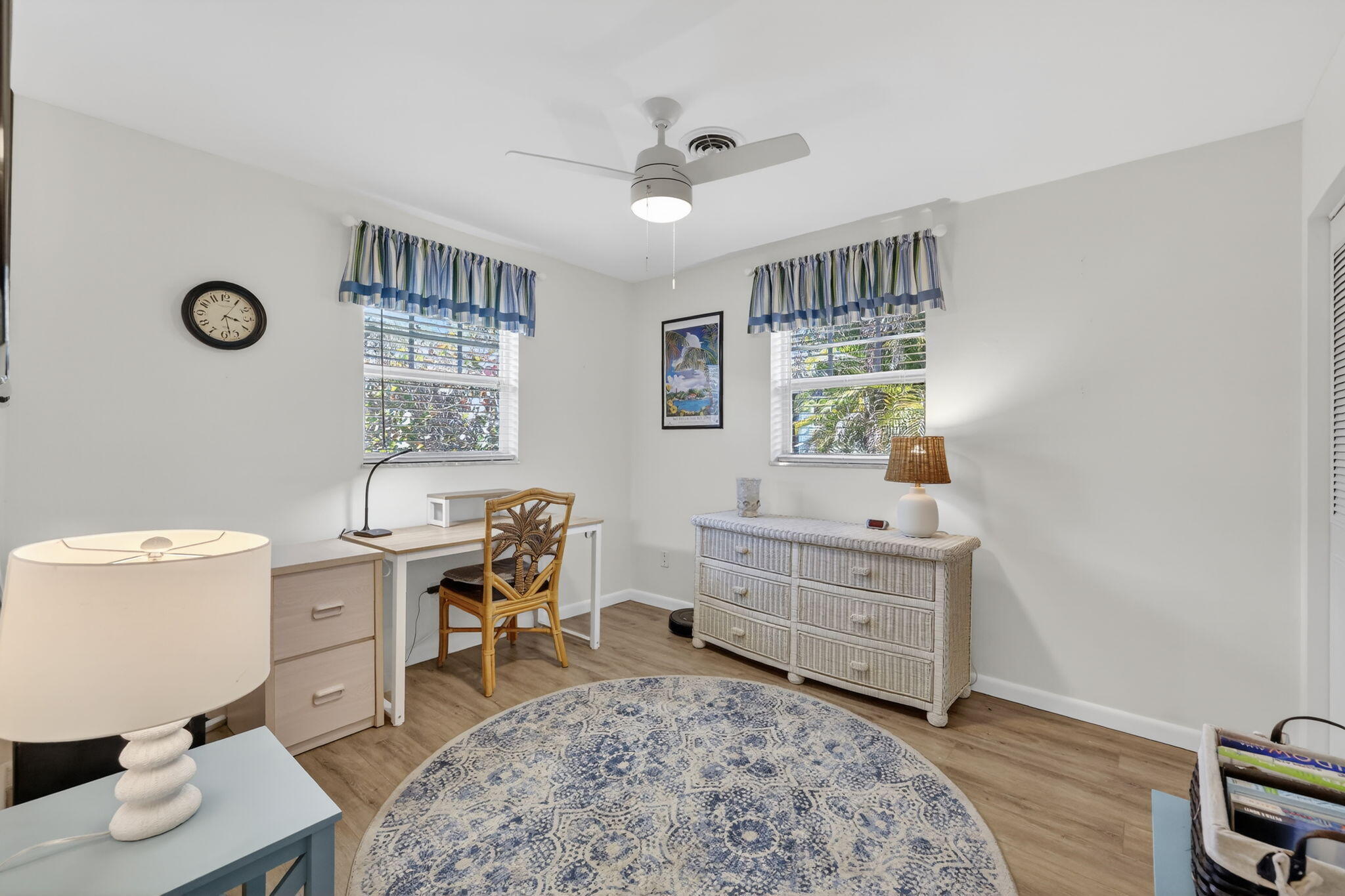 1252 East Madison Avenue Stuart, FL 34996 - Photo 22 of 43 a room with a baby bed a desk and chair with wooden floor