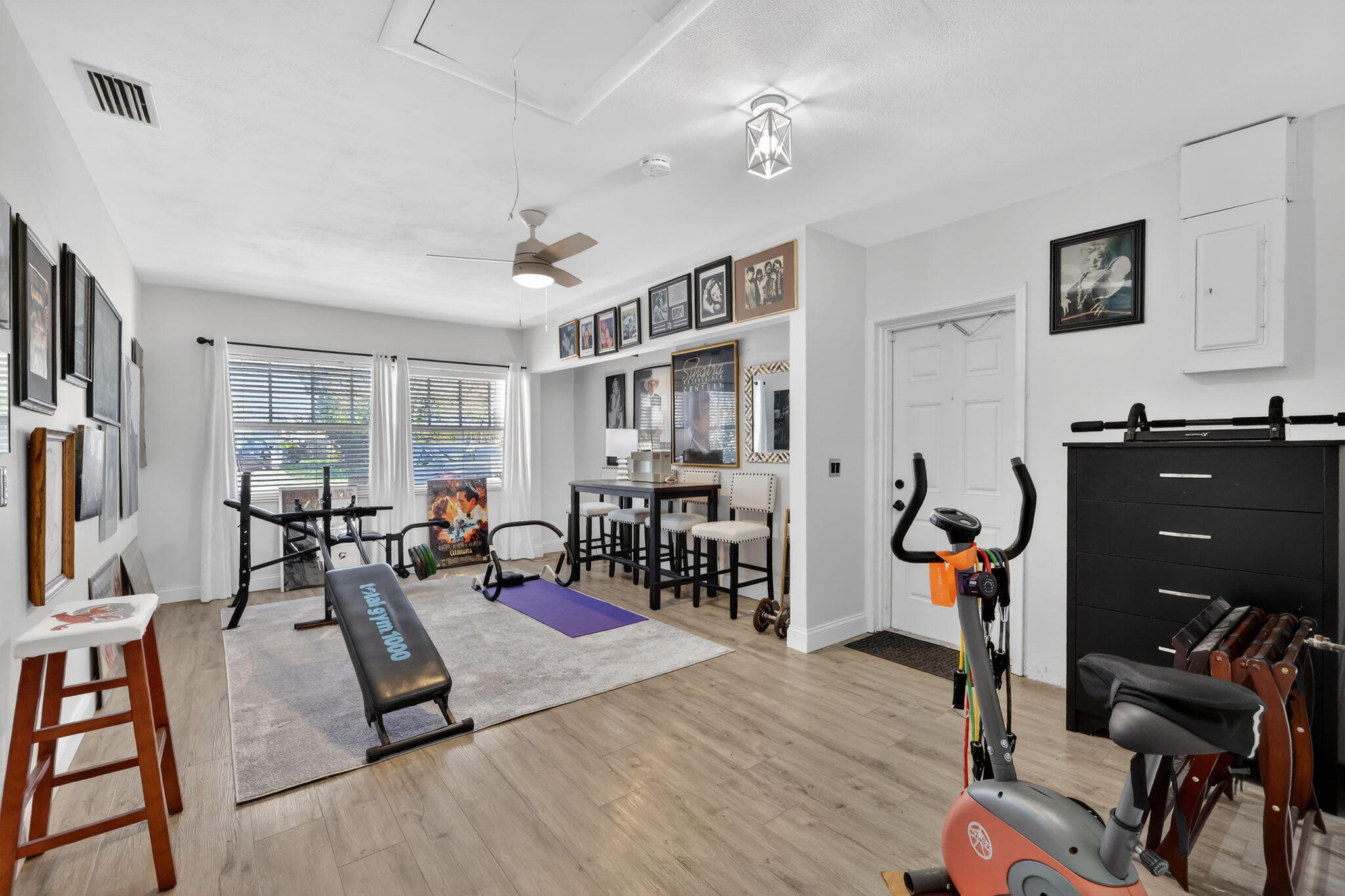 1252 East Madison Avenue Stuart, FL 34996 - Photo 25 of 43 a living room with furniture a flat screen tv and gym equipment