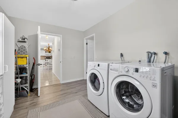 a view of a hallway with washer and dryer to living room