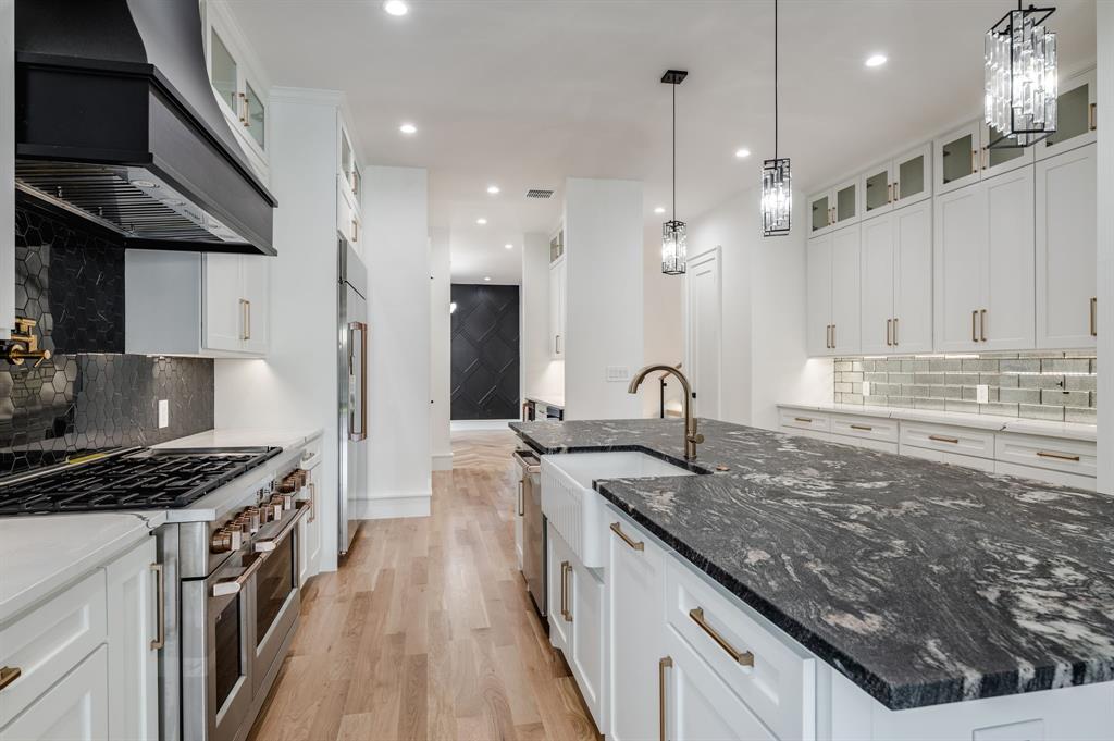 7503 Robin Road Dallas, TX 75209 - Photo 9 of 34 Kitchen with decorative backsplash, glass insert cabinets, dark stone countertops, white cabinets, and recessed lighting