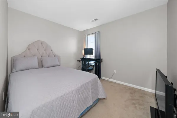 a large bed sitting in a bedroom next to a window with wooden floor