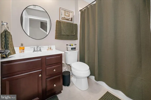a bathroom with a toilet sink vanity and mirror