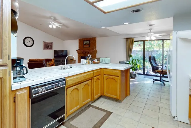 a view of a kitchen with kitchen island a stove a sink a dining table and chairs