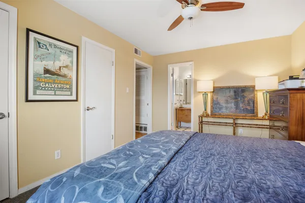 a bedroom with a bed and painting on the wall