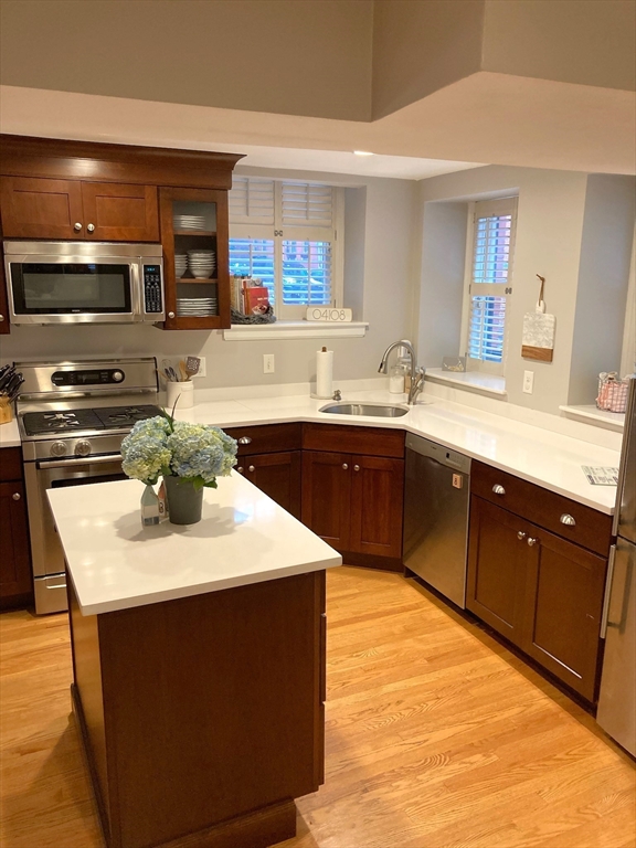 a kitchen with stainless steel appliances kitchen island granite countertop a sink dishwasher stove and oven