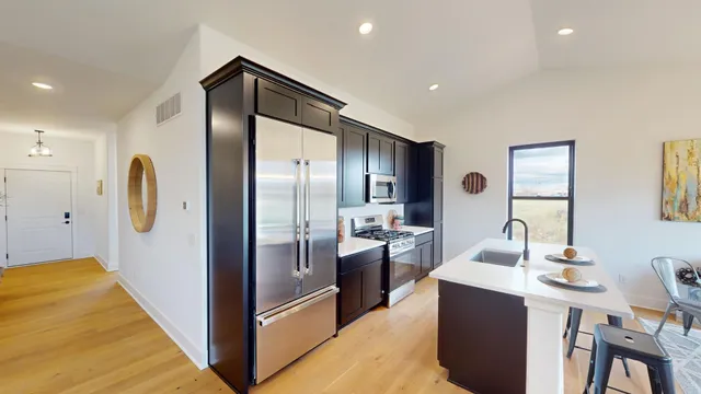 a kitchen with stainless steel appliances a refrigerator and a sink